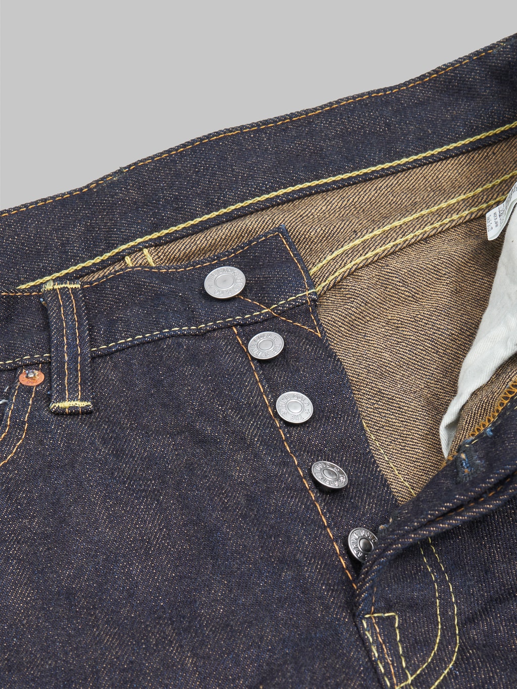 The Strike Gold Brown Weft Slim Tapered Jeans iron buttons